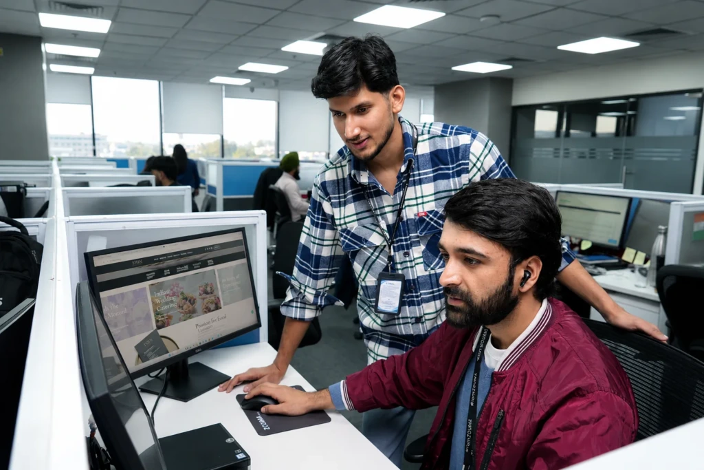 Two ZOUMA engineers reviewing a client website together at a workstation